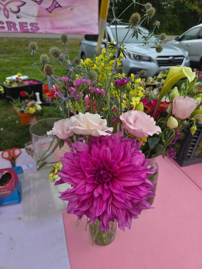 A finished bouquet standing in a jar on Wendy’s market table at Firefly Acres